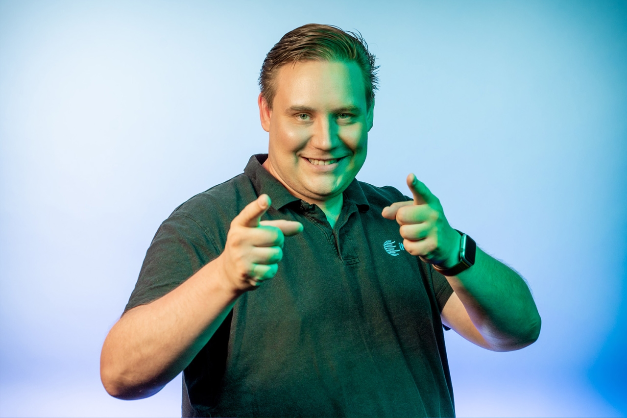 Man smiling and pointing with both fingers at the camera