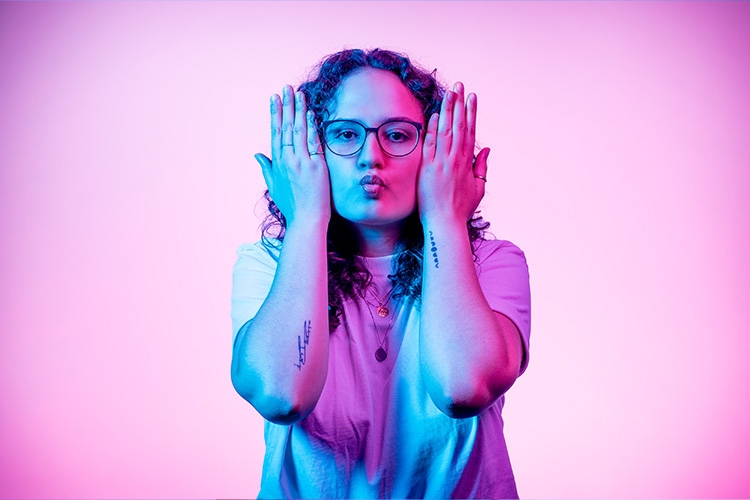 Woman makes a fish mouth and holds her hands next to her face