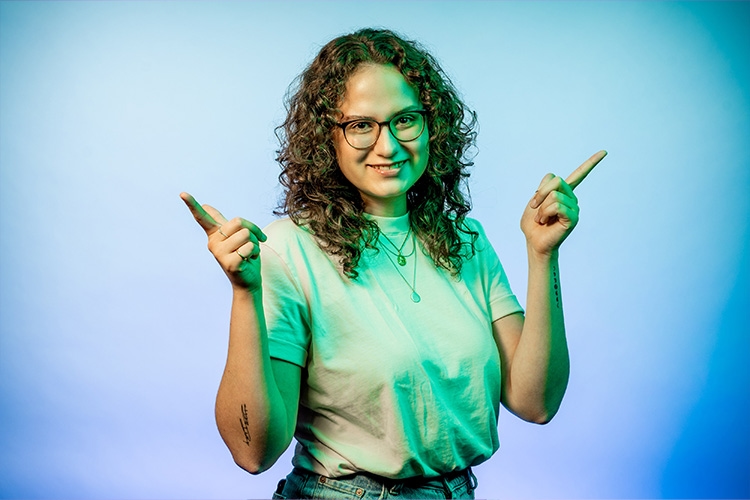 Woman holds hands up and has index fingers spread apart