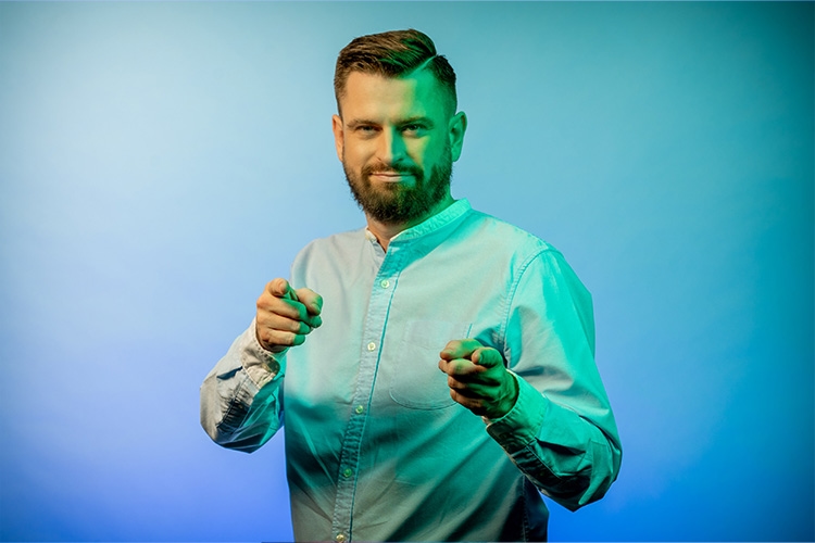 Mann zeigt mit beiden Zeigefingern nach vorne 