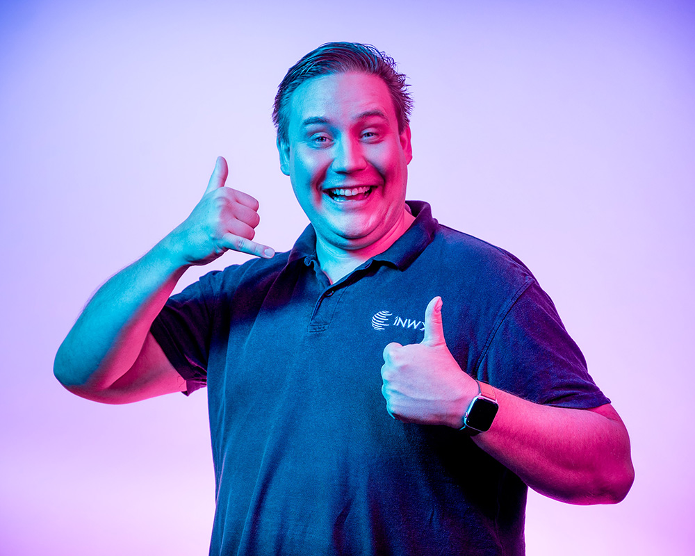 Ein Mann hält sich die Hand wie ein Telefon ans Ohr, mit der anderen zeigt er Daumen hoch