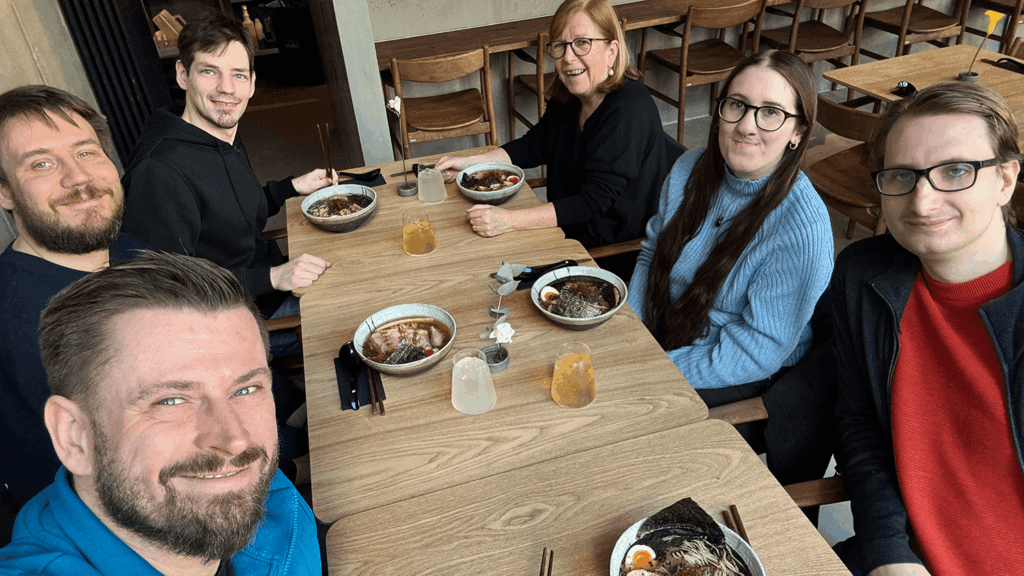 Selfie von sechs Personen beim Essen