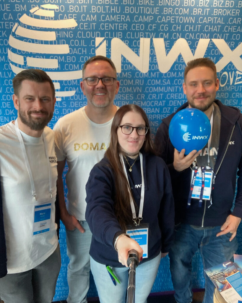 Selfie of four people in front of the INWX booth